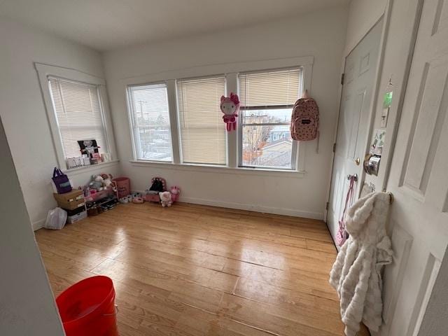 recreation room with light wood finished floors and baseboards