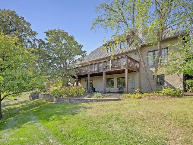 back of property featuring a yard and a wooden deck