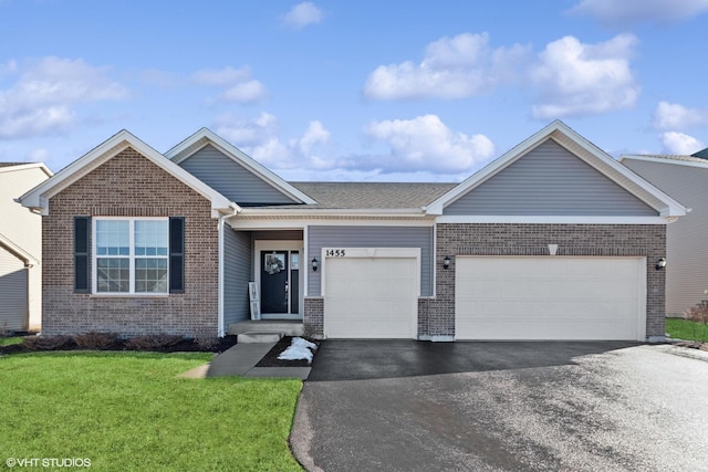 ranch-style house featuring a garage, brick siding, and aphalt driveway