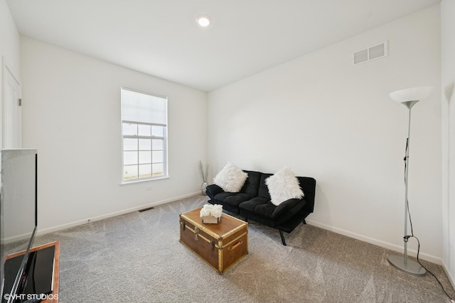 living area featuring baseboards, visible vents, and carpet flooring