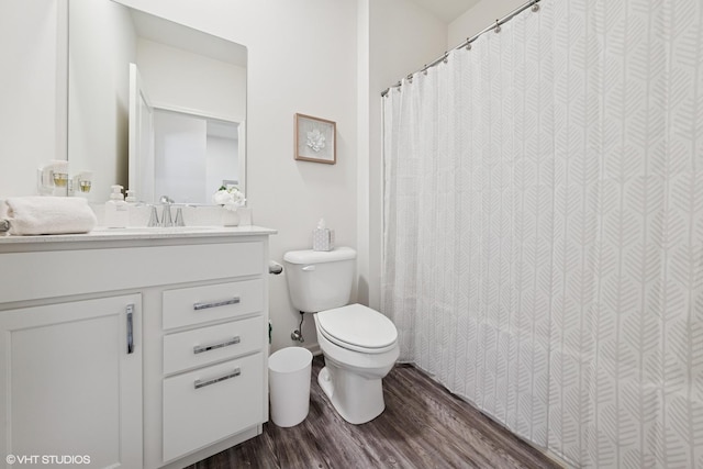 bathroom featuring vanity, curtained shower, wood finished floors, and toilet