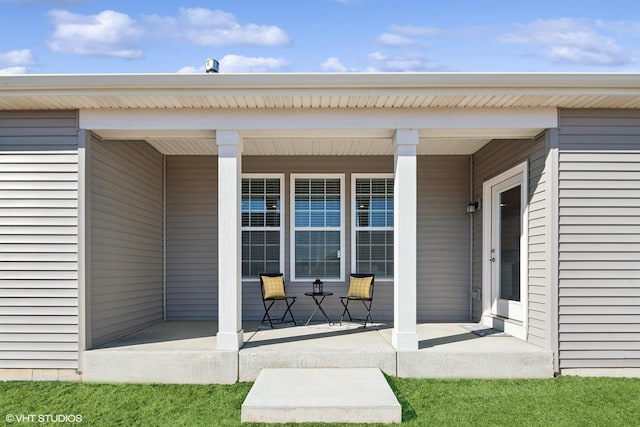 view of exterior entry featuring covered porch