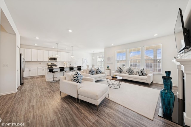 living area featuring baseboards, a fireplace, wood finished floors, and recessed lighting