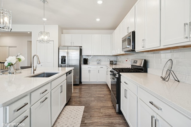 kitchen with stainless steel appliances, decorative backsplash, dark wood-type flooring, white cabinets, and a sink