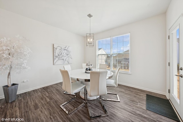 dining area featuring an inviting chandelier, baseboards, and dark wood finished floors