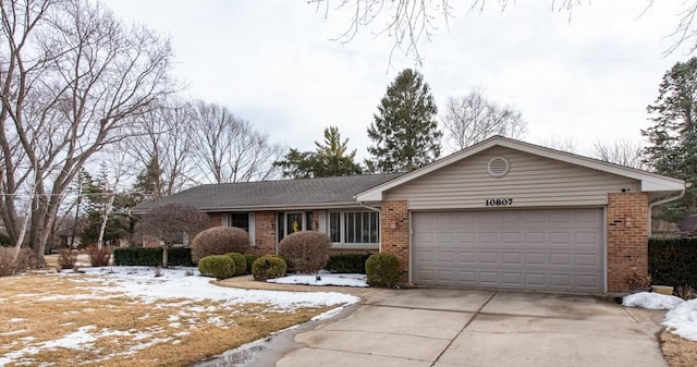 ranch-style house with a garage, concrete driveway, and brick siding