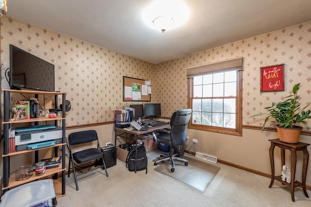 carpeted office space with baseboards, visible vents, and wallpapered walls