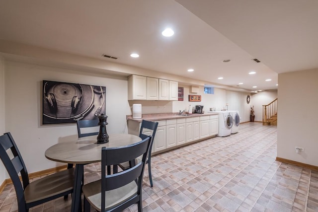 kitchen featuring washer and clothes dryer, recessed lighting, visible vents, and white cabinetry