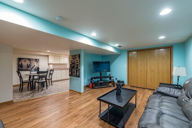 living room featuring light wood-type flooring, visible vents, baseboards, and recessed lighting