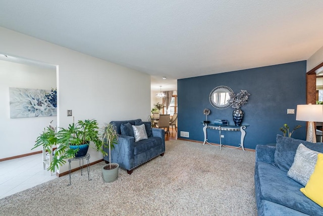 living area featuring an accent wall, carpet, visible vents, and baseboards