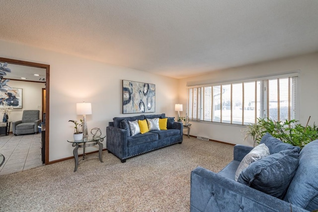 living room featuring light carpet, a textured ceiling, visible vents, and baseboards