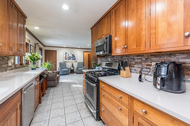 kitchen featuring light tile patterned flooring, stainless steel appliances, open floor plan, light countertops, and brown cabinets