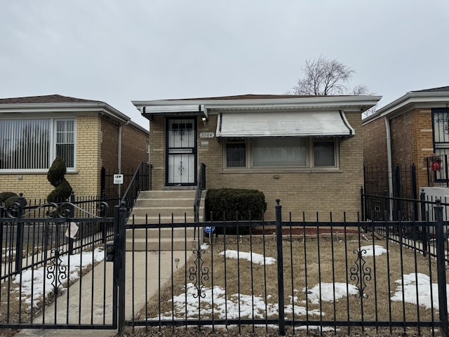 bungalow with brick siding and a fenced front yard