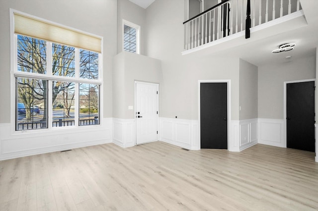 foyer entrance with wood finished floors and wainscoting