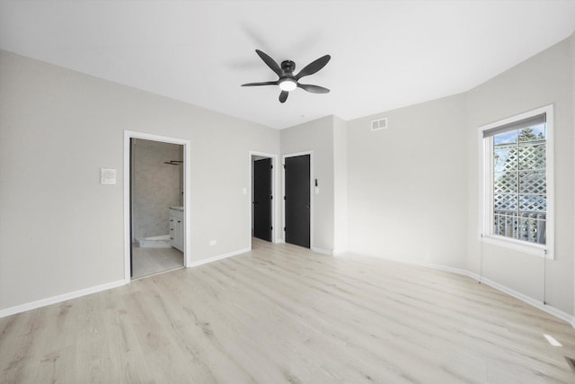 unfurnished bedroom featuring light wood finished floors, visible vents, baseboards, ensuite bathroom, and a ceiling fan