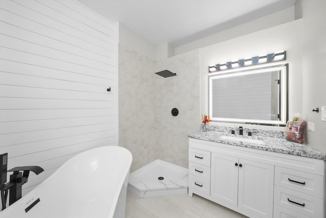 bathroom with vanity, a freestanding tub, and tiled shower