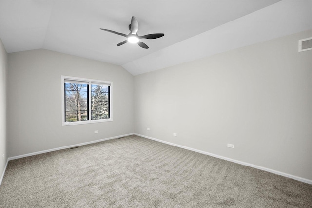 carpeted empty room featuring visible vents, baseboards, ceiling fan, and vaulted ceiling