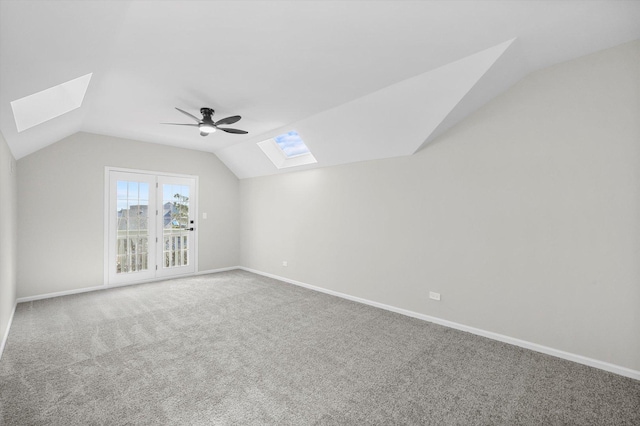 bonus room with a ceiling fan, lofted ceiling with skylight, carpet, and baseboards