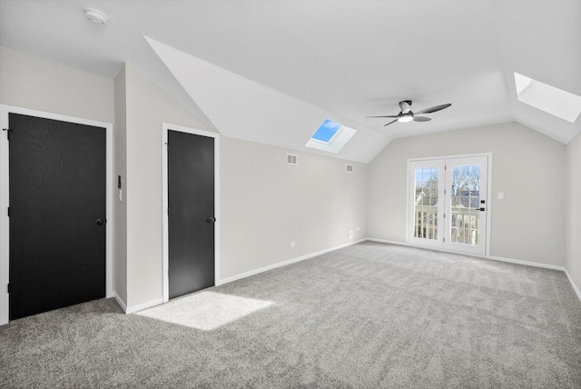 bonus room featuring lofted ceiling with skylight, carpet flooring, and baseboards