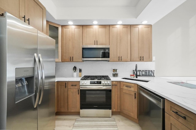 kitchen with a sink, light stone counters, recessed lighting, appliances with stainless steel finishes, and glass insert cabinets