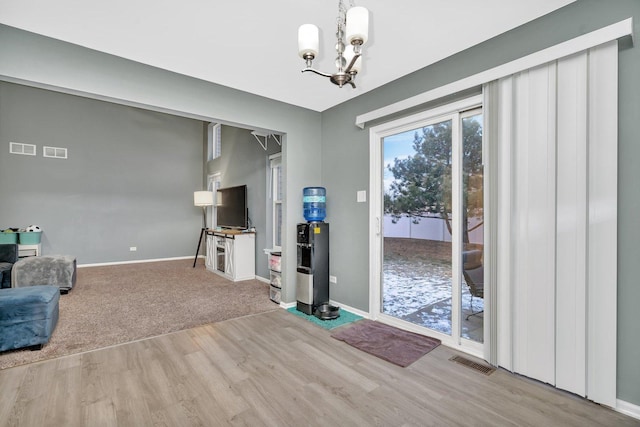 living area featuring light wood finished floors, visible vents, and baseboards