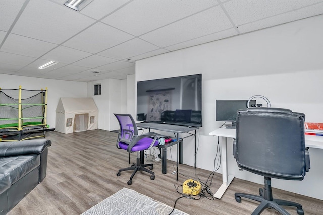 office featuring a paneled ceiling, visible vents, and wood finished floors