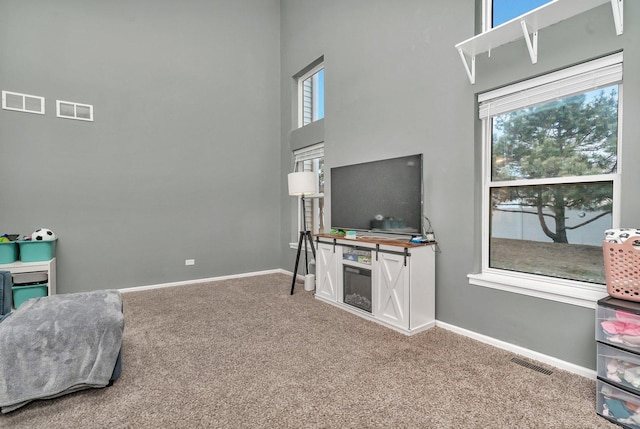 rec room featuring carpet floors, a healthy amount of sunlight, and visible vents