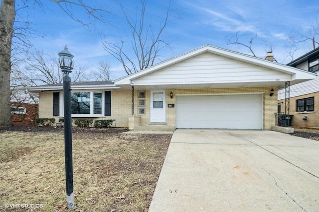 single story home featuring a garage, concrete driveway, and brick siding