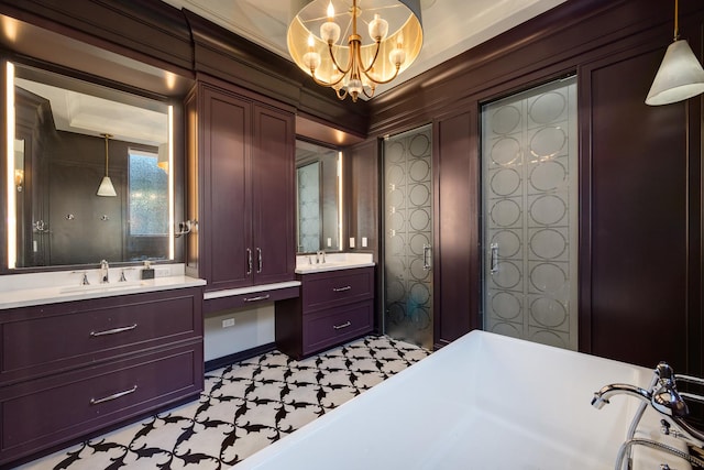 bathroom with a sink, a freestanding tub, two vanities, and a notable chandelier