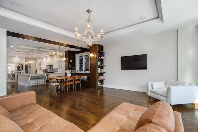 living room featuring dark wood-style floors, baseboards, a raised ceiling, and a notable chandelier