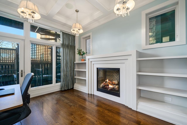 unfurnished office featuring a chandelier, a lit fireplace, dark wood-style flooring, and coffered ceiling