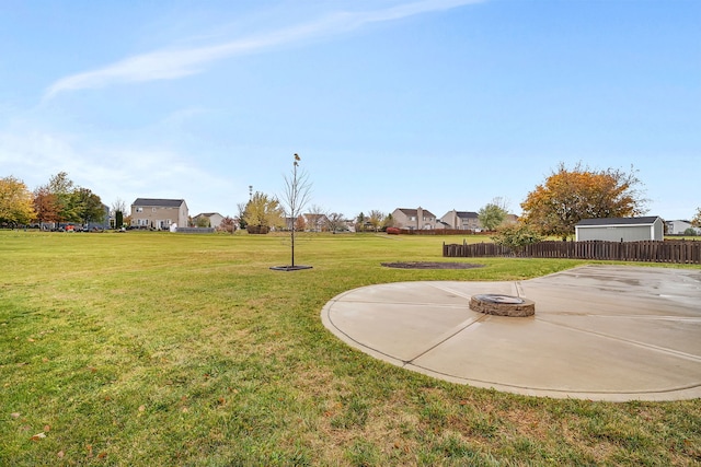 view of yard featuring a patio area, an outdoor fire pit, a residential view, and fence