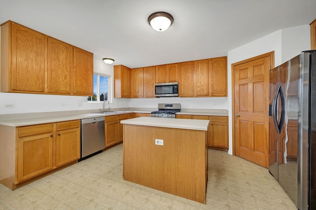 kitchen with a center island, stainless steel appliances, light countertops, light floors, and a sink