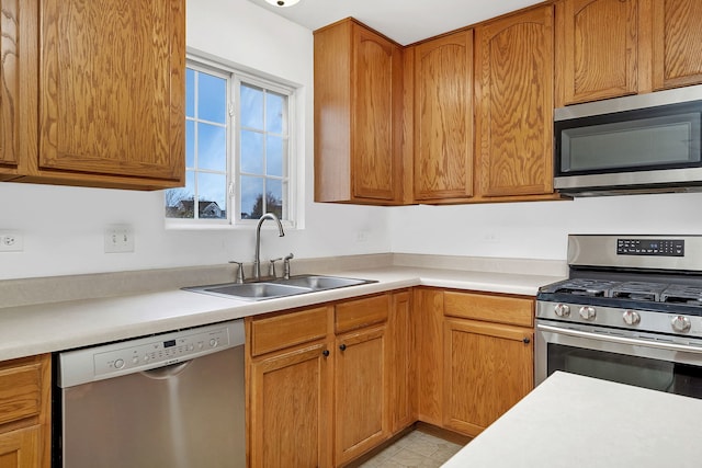 kitchen featuring stainless steel appliances, light countertops, and a sink