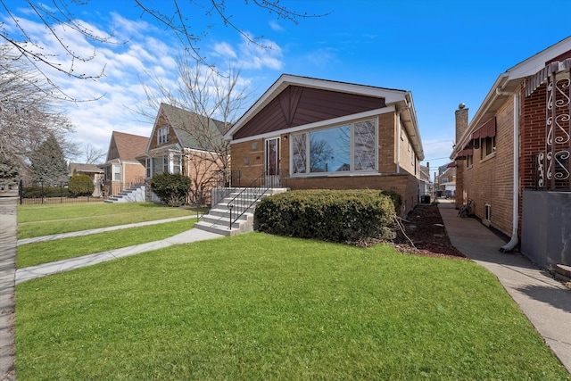 view of front of home featuring a front lawn and brick siding