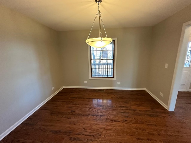 spare room with dark wood finished floors and baseboards