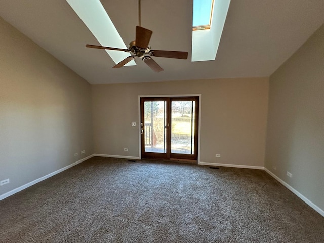 unfurnished room with lofted ceiling with skylight, baseboards, dark carpet, and a ceiling fan