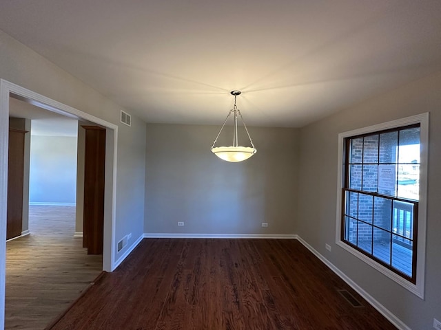 spare room with dark wood-style floors, baseboards, and visible vents