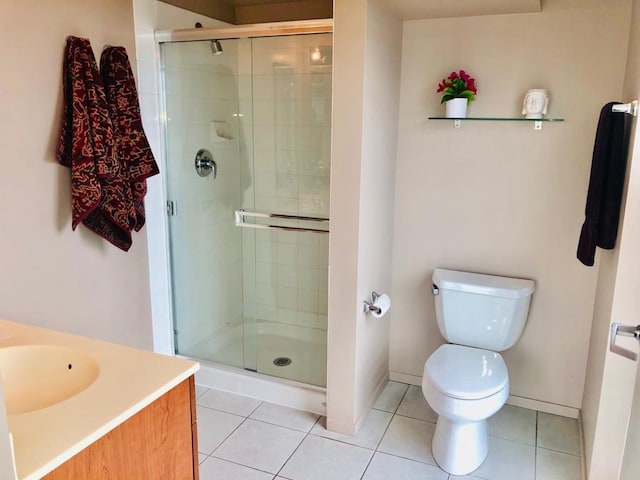 full bathroom featuring tile patterned flooring, toilet, vanity, baseboards, and a shower stall