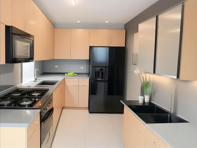 kitchen featuring black appliances, light tile patterned floors, light countertops, and a sink