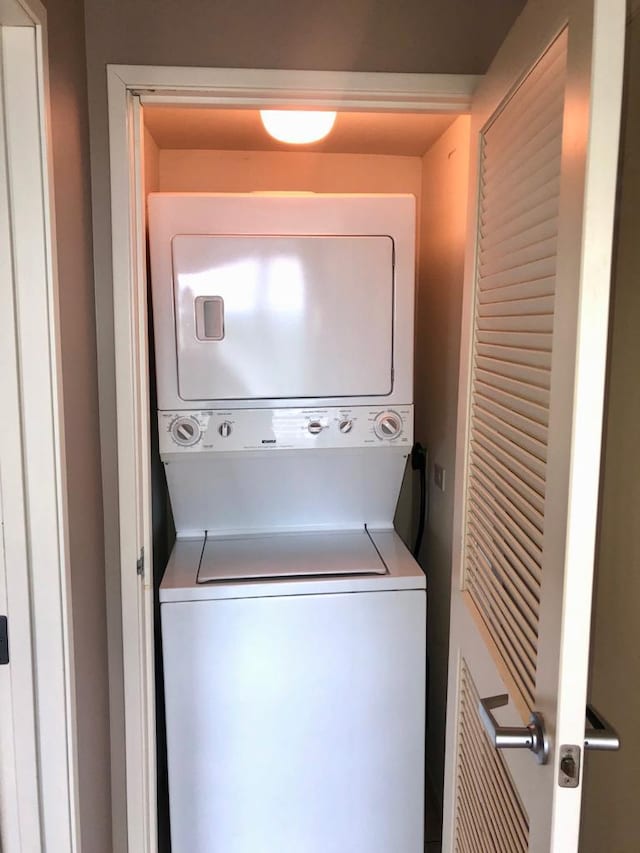 clothes washing area with laundry area and stacked washer and clothes dryer