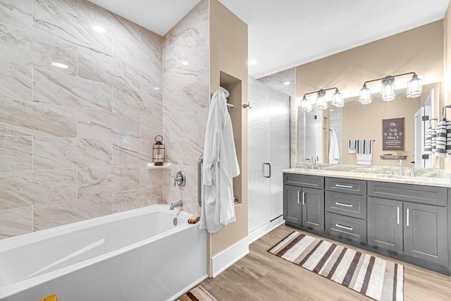 bathroom with double vanity, a sink, baseboards, and wood finished floors