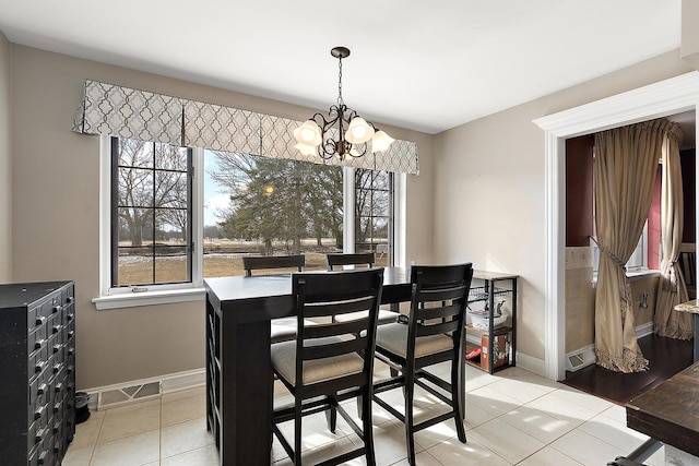 dining room with light tile patterned floors, a chandelier, visible vents, and a healthy amount of sunlight