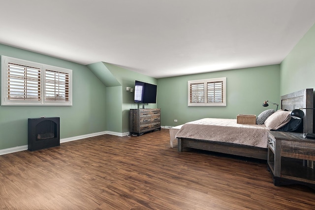 bedroom with multiple windows, wood finished floors, and baseboards