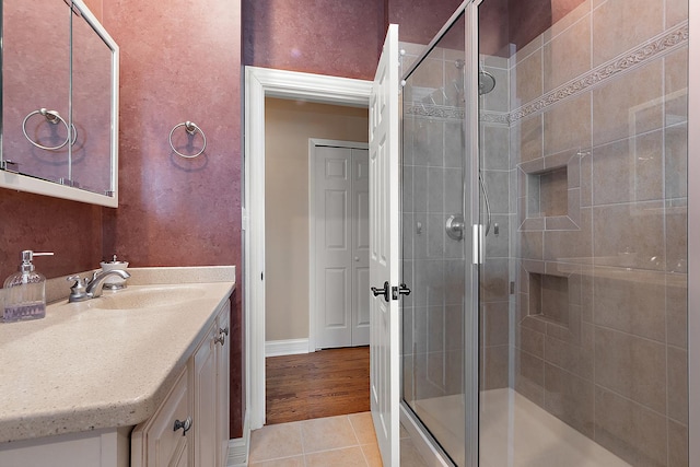 full bathroom featuring tile patterned flooring, a shower stall, and vanity