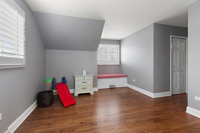 interior space featuring lofted ceiling, visible vents, baseboards, and wood finished floors