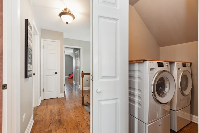 laundry room featuring laundry area, baseboards, separate washer and dryer, and wood finished floors