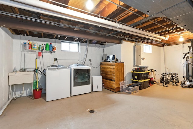 below grade area featuring washing machine and dryer, electric panel, and a sink