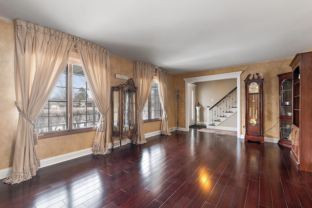 unfurnished room featuring stairway, baseboards, and wood finished floors