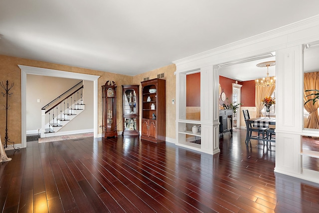 interior space with baseboards, a notable chandelier, stairway, and wood finished floors